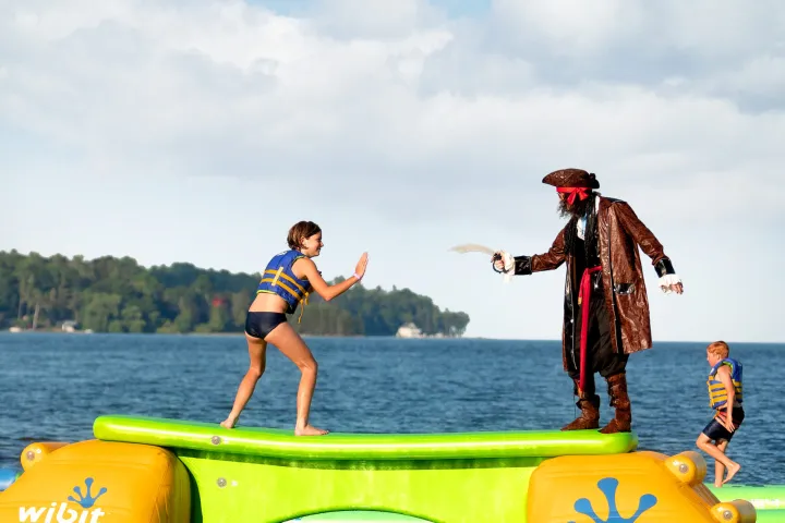 a group of people riding on the back of a boat in the water