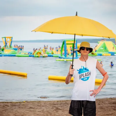 a person holding an umbrella in front of a beach