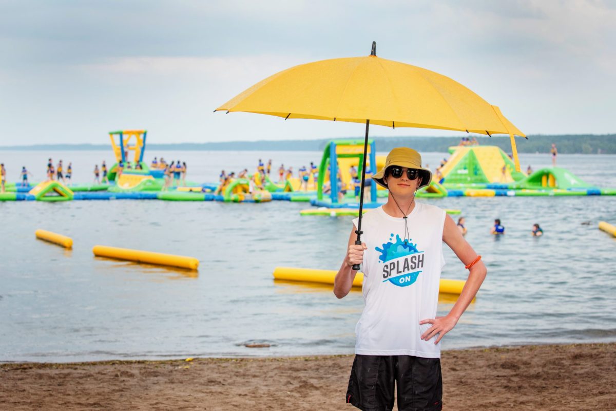 5S0A2423 a person holding an umbrella in front of a beach
