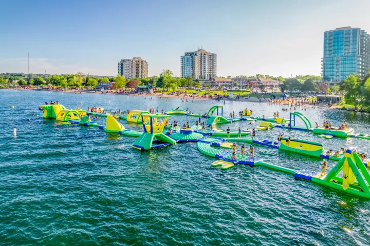a group of people flying kites in a body of water
